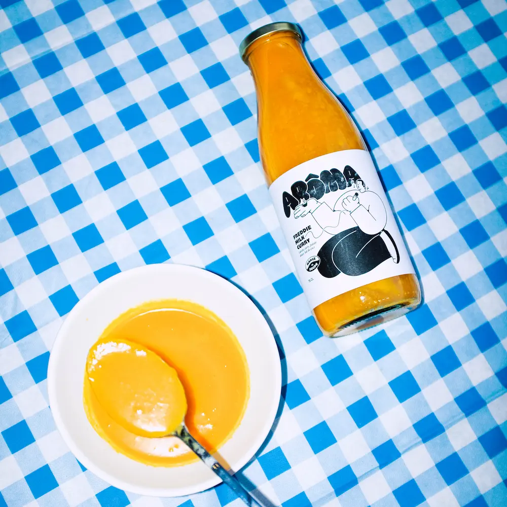 La soupe aroma Freddi Milk Curry dans un bol sur une nappe à carreaux bleu et blanc